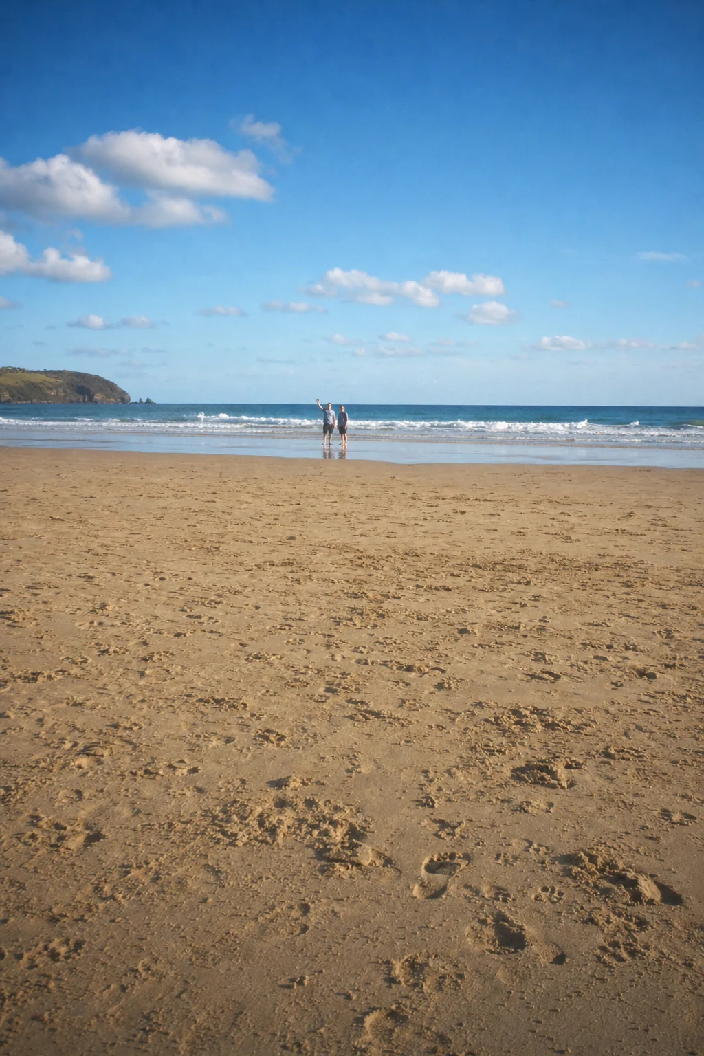 A sandy beach with two people far away, as Pokkto sees it, in the chosen filter
